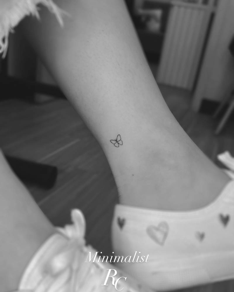 Tiny minimalistic butterfly tattoo located on the ankle.