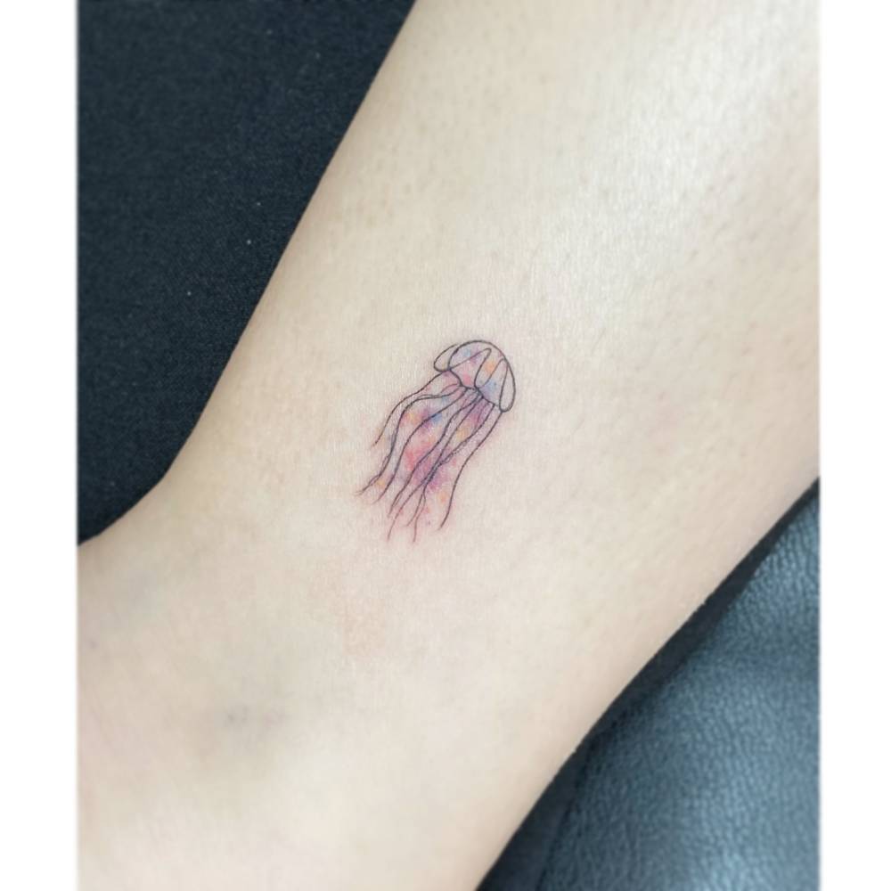 Illustrative style jellyfish tattoo placed on the ankle.