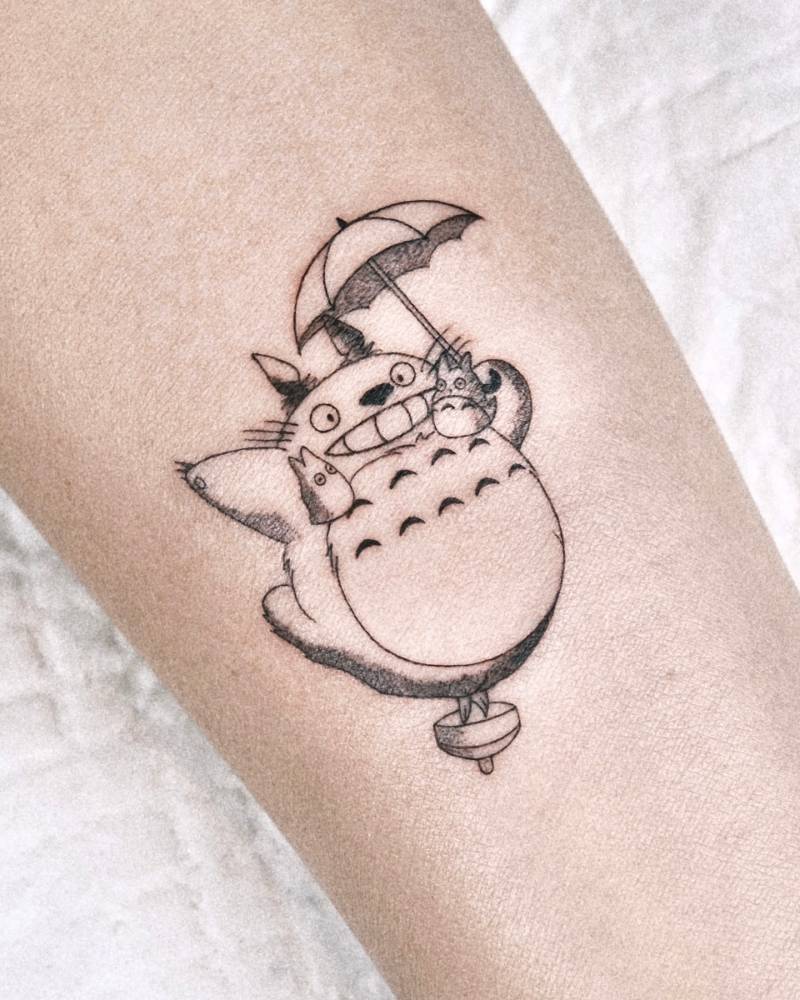 Cartoon style Totoro tattoo located on the inner forearm.