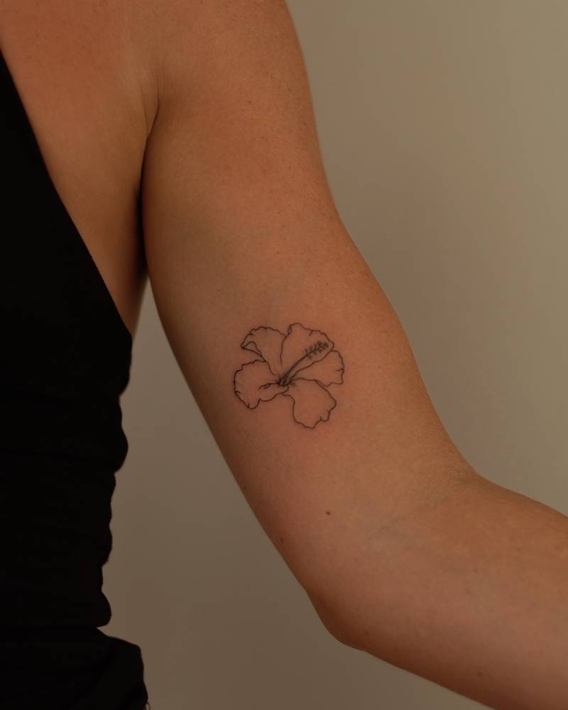 Hibiscus flower tattoo in fine line style placed on the inner arm.