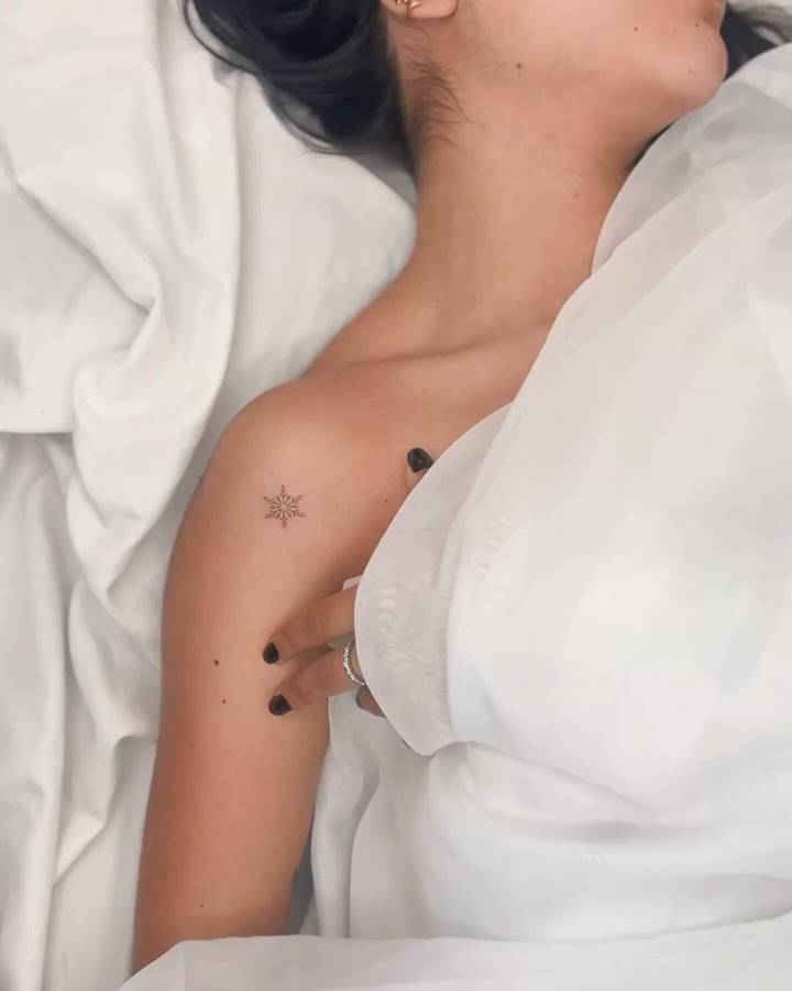 Snowflake tattoo in fine line style done on the shoulder.