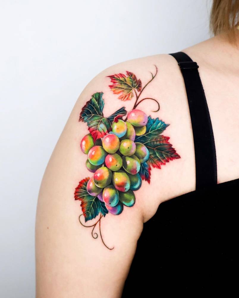 Grapes tattoo in realism located on the shoulder.