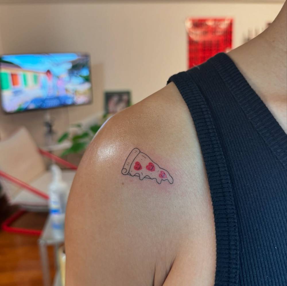 Pepperoni pizza tattoo in illustrative style located on the shoulder.