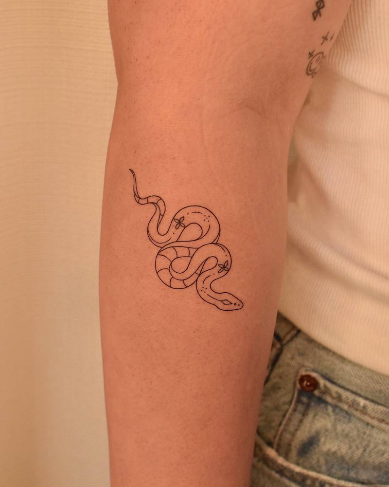Snake tattoo in fine line style located on the forearm.