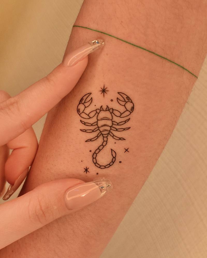 Fine line style scorpion tattoo located on the forearm.