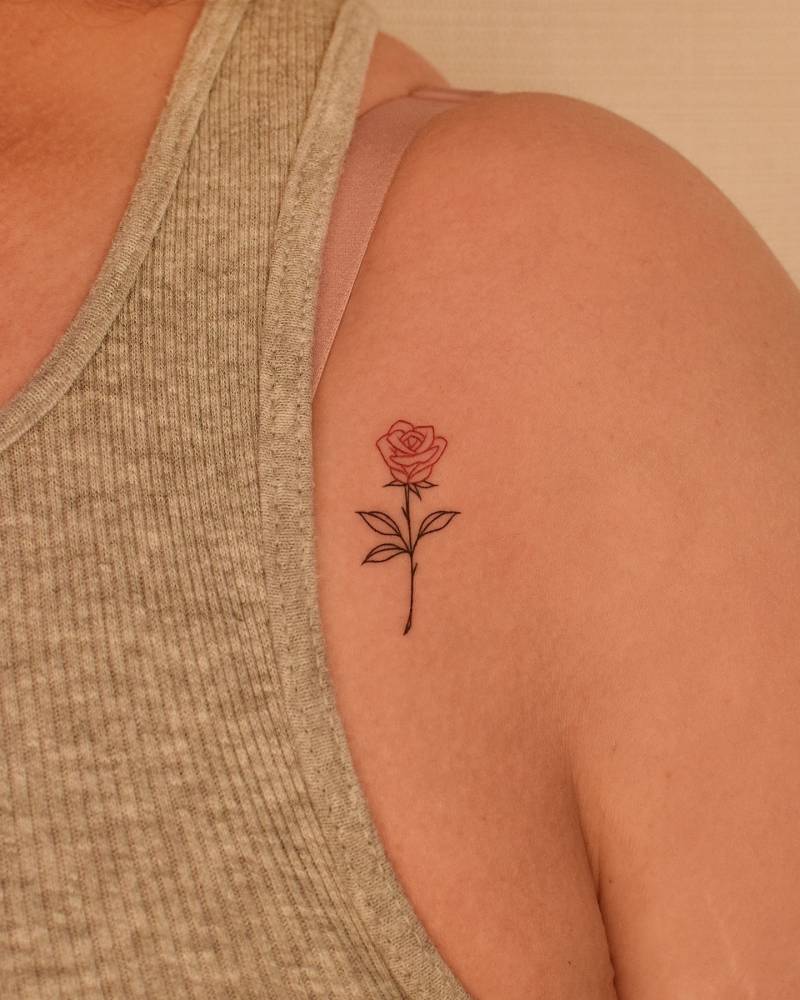 Fine line style red rose tattoo located on the shoulder.
