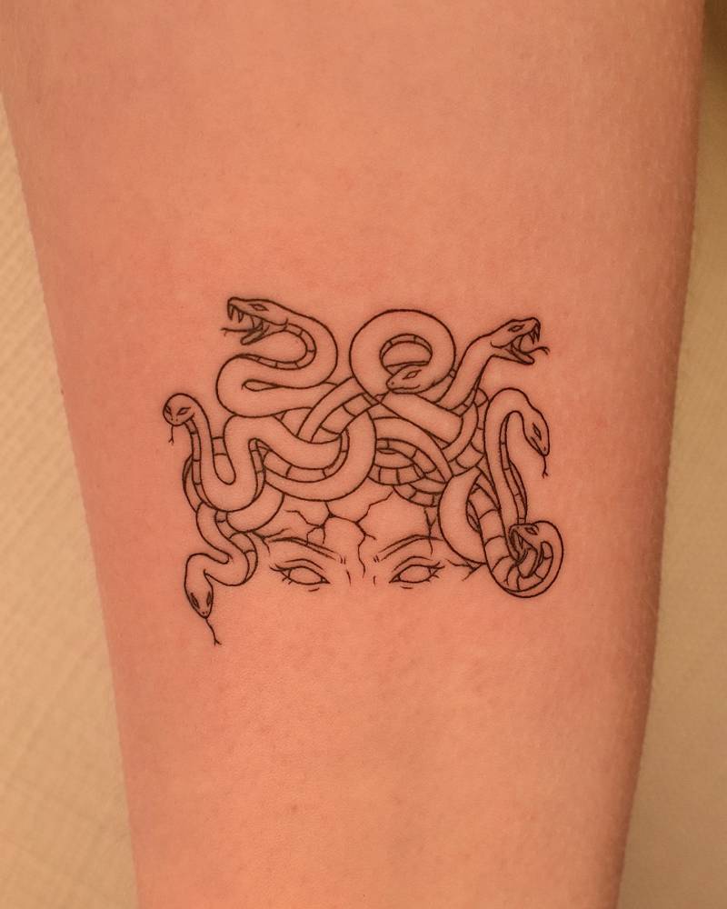 Fine line style Medusa tattoo located on the inner forearm.
