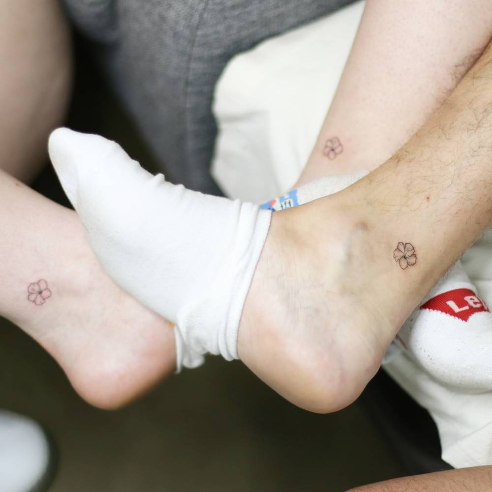 Matching minimalistic style hibiscus flower tattoo for siblings.