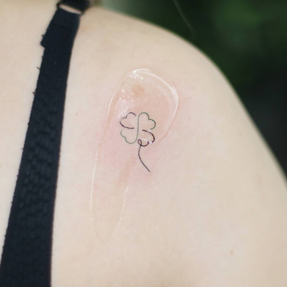 Four leaf clover tattoo in fine line style done on the shoulder