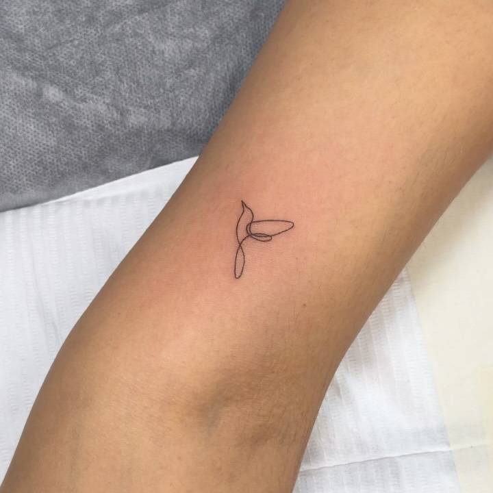 One line hummingbird tattoo located on the inner arm.