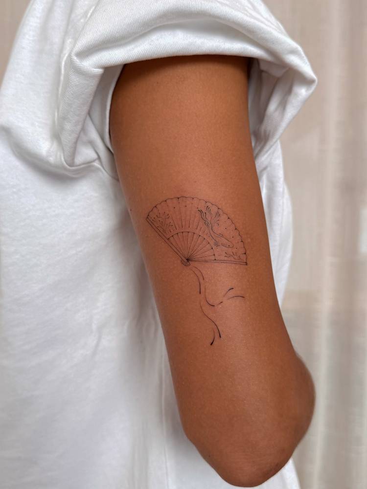 Hand fan tattoo placed on the tricep, done in fine line style.