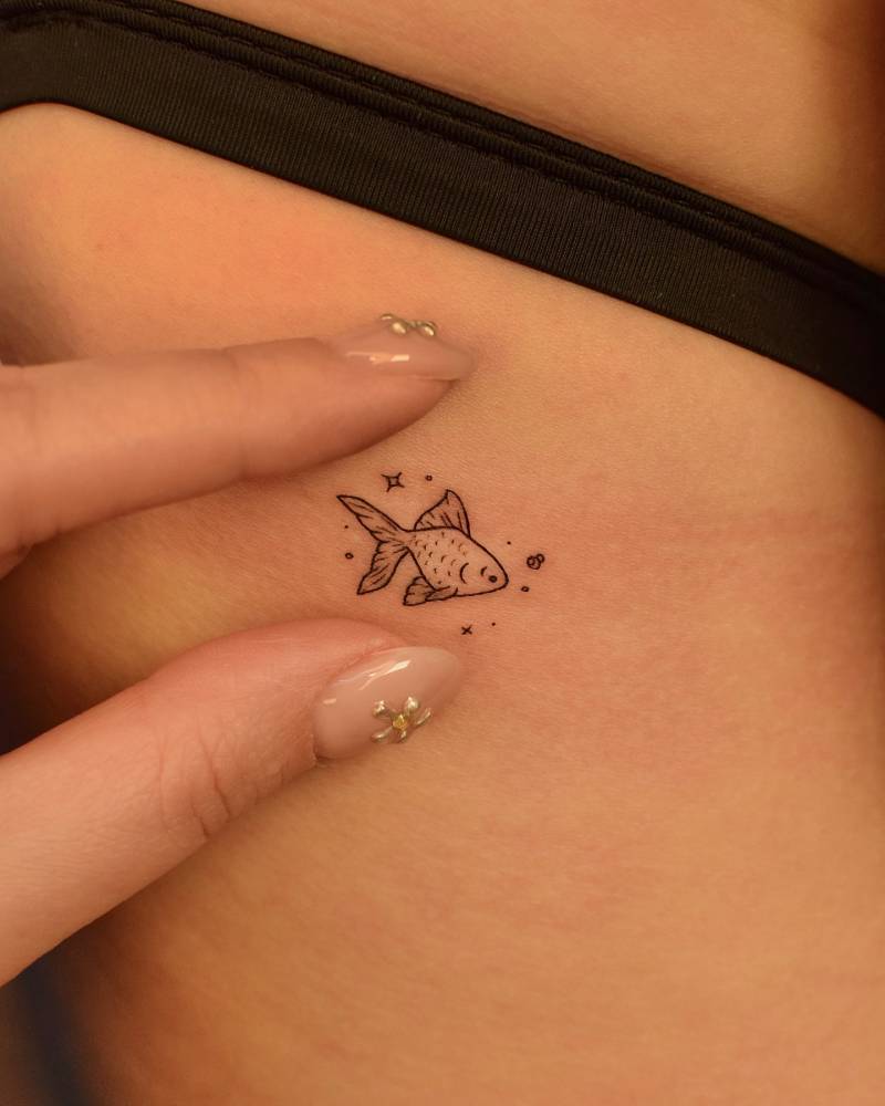Illustrative style little fish tattoo located on the back.
