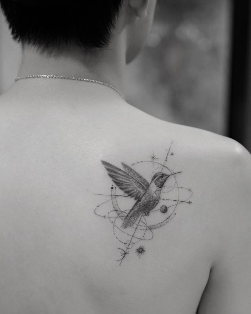 Micro-realistic style hummingbird tattoo located on the shoulder blade.