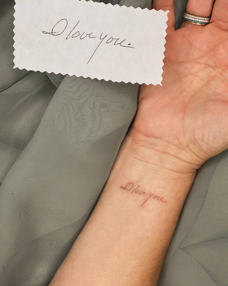 Handwritten "I love you" lettering tattoo located on the wrist.