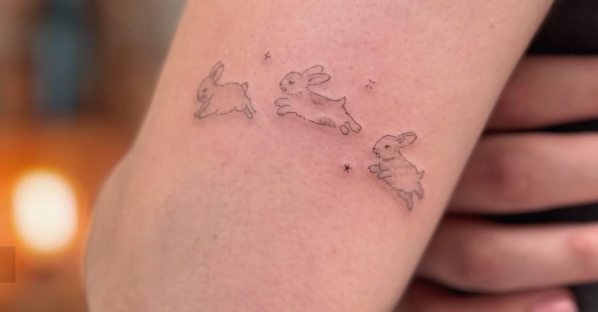 Fine line style jumping rabbit tattoo located on the