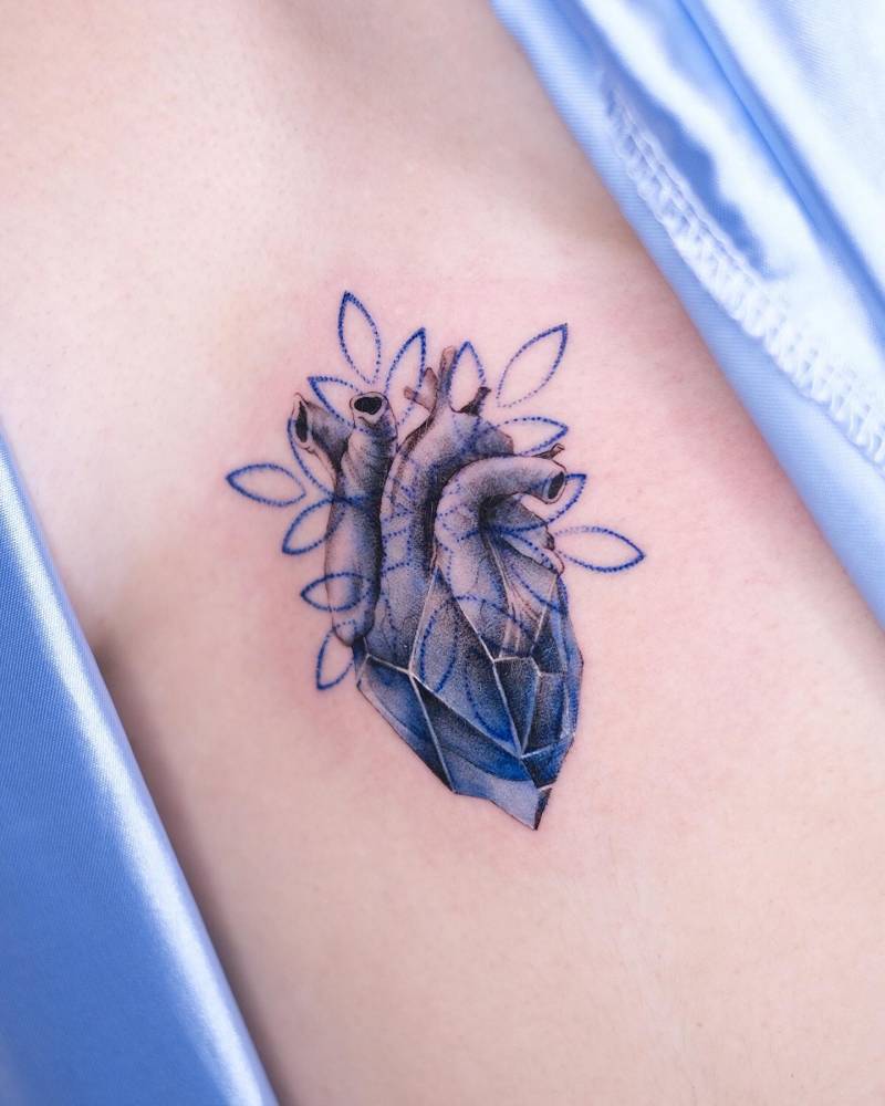 Anatomical heart tattoo located on the sternum.