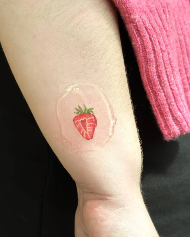 Illustrative style strawberry tattoo located on the wrist.