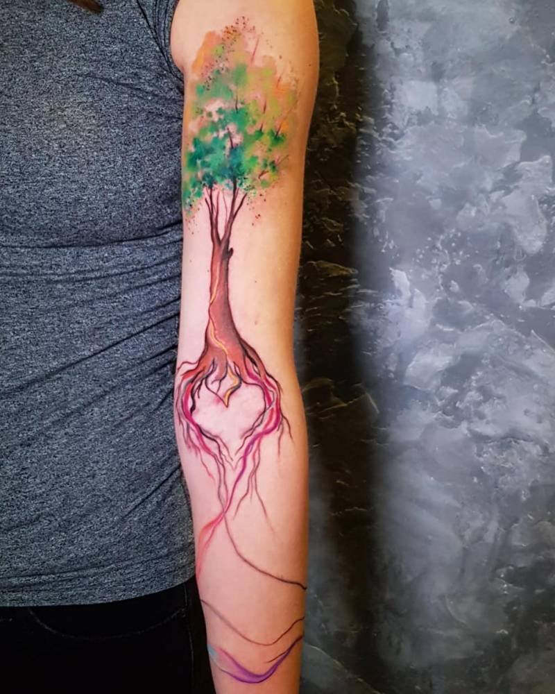 Watercolor tree tattoo located on the arm.