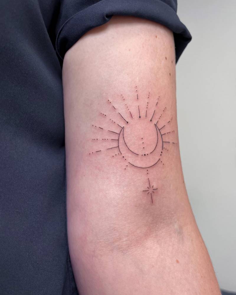 Fine line style sun and moon tattoo done on the bicep.