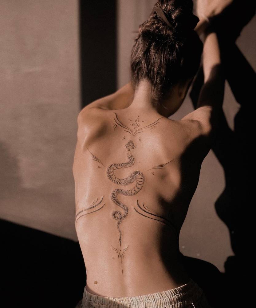 Huge ornamental snake tattoo located on the back.