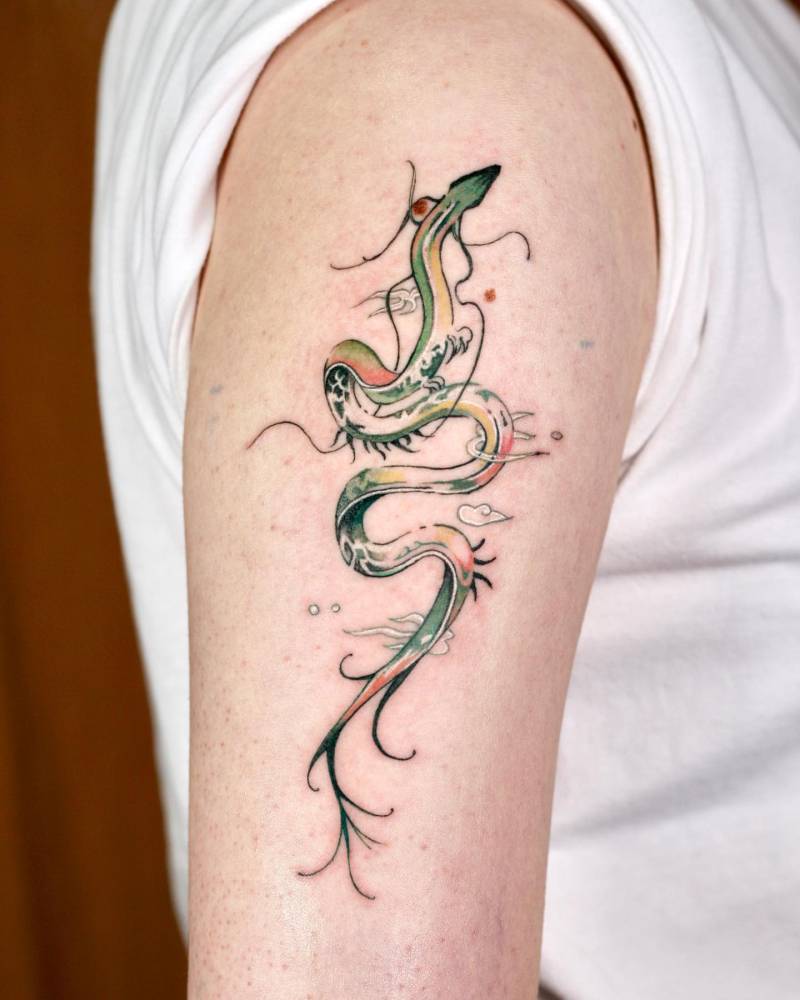 Dragon tattoo in watercolor style located on the upper arm.