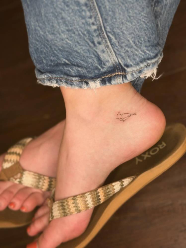 Minimalistic cardinal tattoo in fine line style done on the ankle.