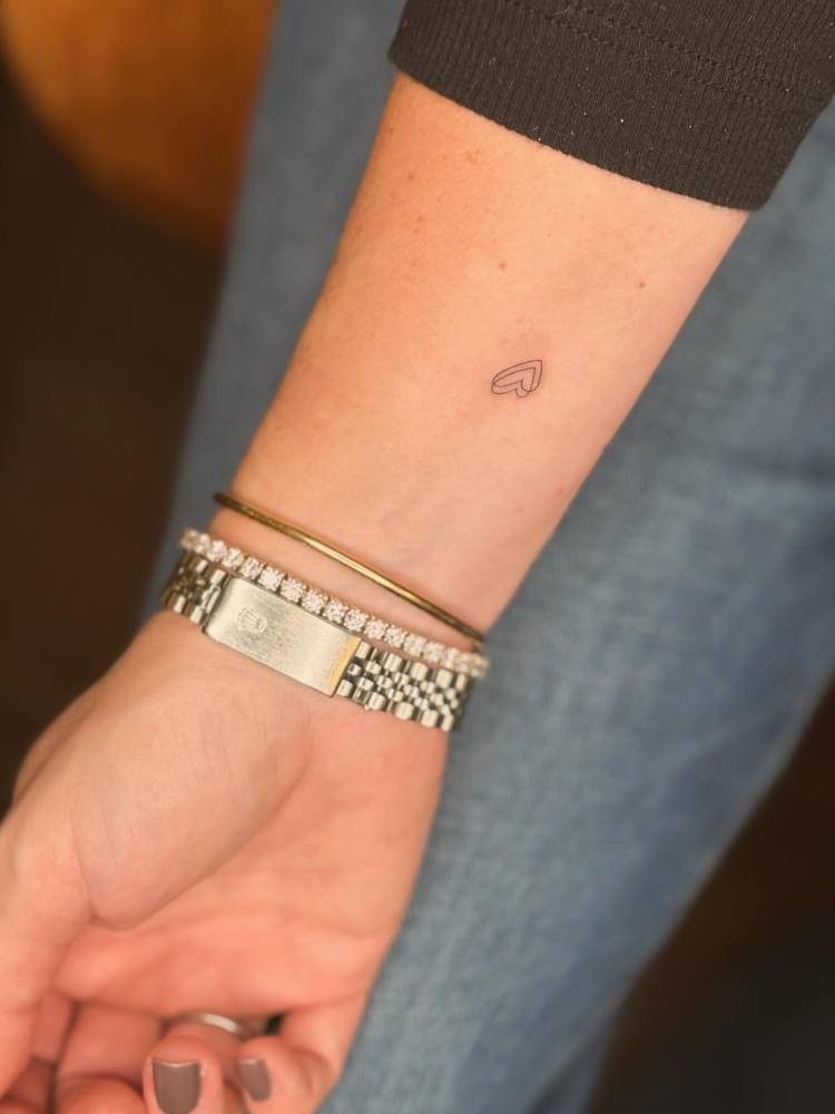 Minimalistic heart tattoo located on the wrist.