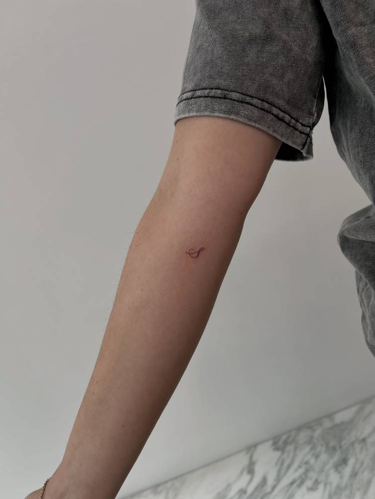Little letter "S" tattoo located on the inner forearm.