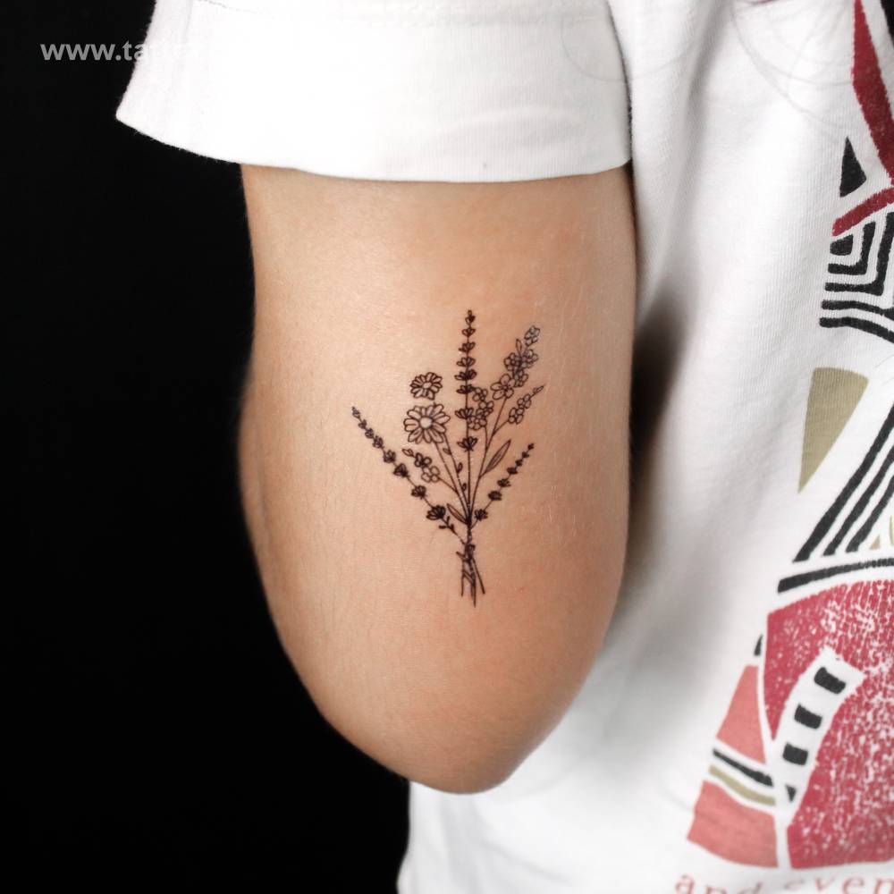 Wild flower bouquet semi-permanent tattoo located on the tricep.