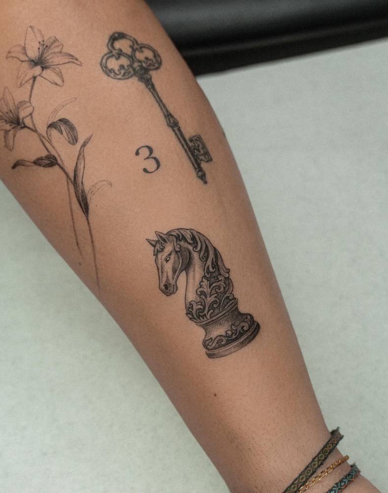 Chess knight tattoo in illustrative style done on the achilles.