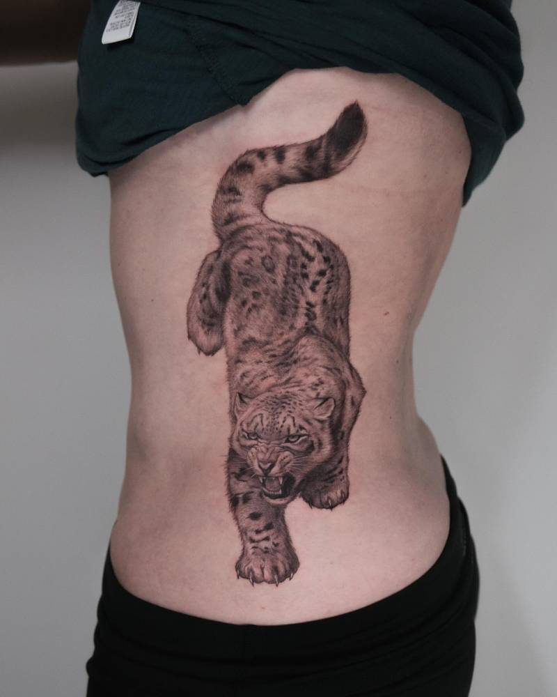 Huge black and grey style snow leopard tattoo.