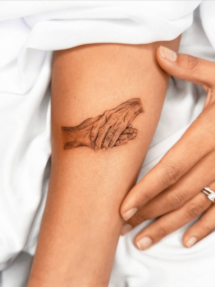 Micro-realistic style hands tattoo located on the inner forearm.