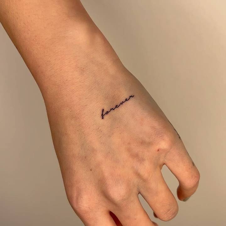 Tattoo of the word "forever" done on the hand.