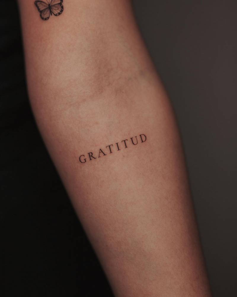 Tattoo of the word "gratitud" located on the inner forearm.