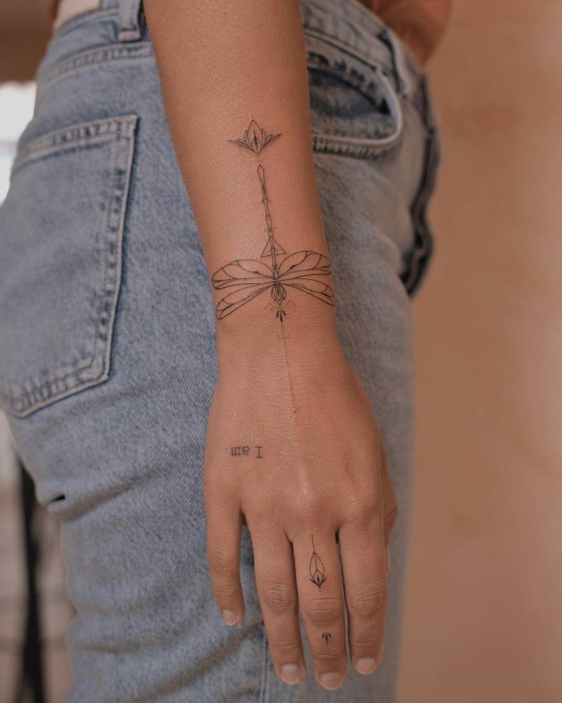 Hand poked dragonfly tattoo located on the wrist.