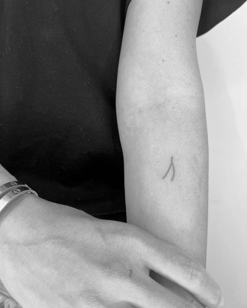 Single needle wishbone tattoo done on the inner forearm.