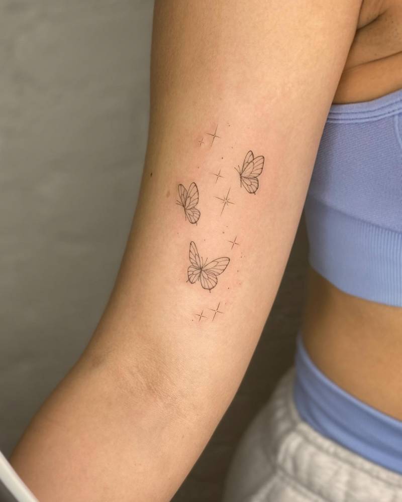 Butterflies and sparkling stars tattoo located on the inner arm.