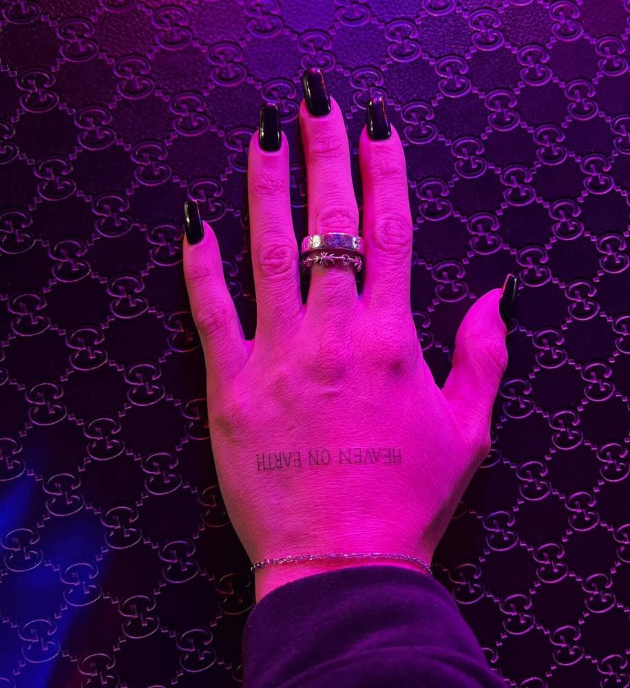 "Heaven on earth" lettering tattoo placed on the hand.