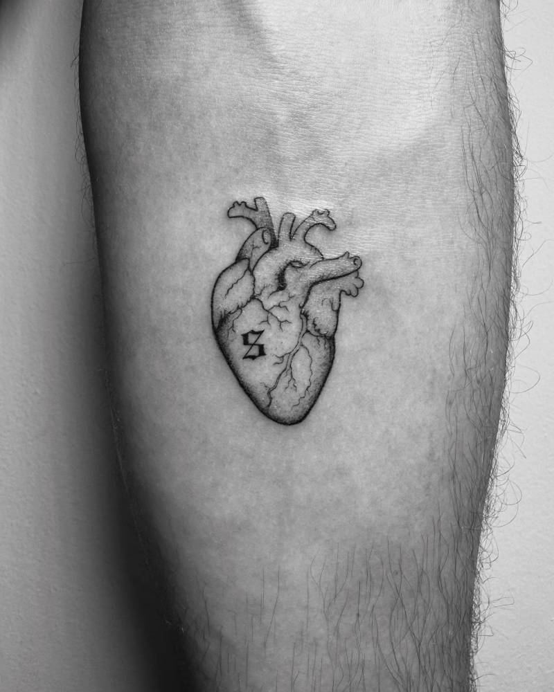 Anatomical heart and letter "S" tattoo located on the inner forearm.