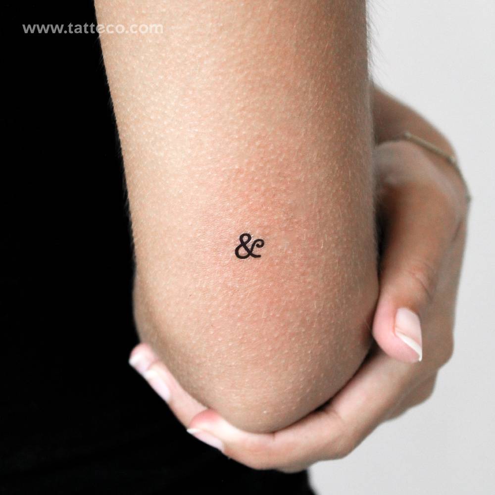 Tiny minimalistic ampersand temporary tattoo located on the tricep.