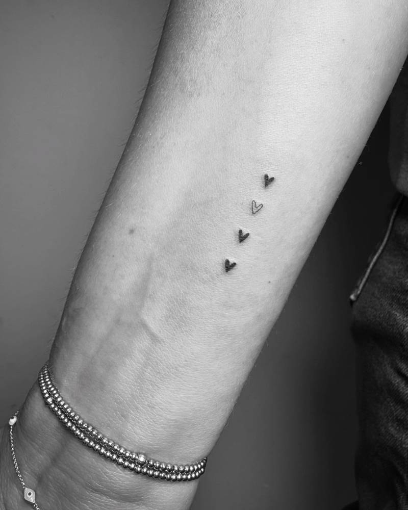 Minimalistic little hearts tattoo done on the wrist.