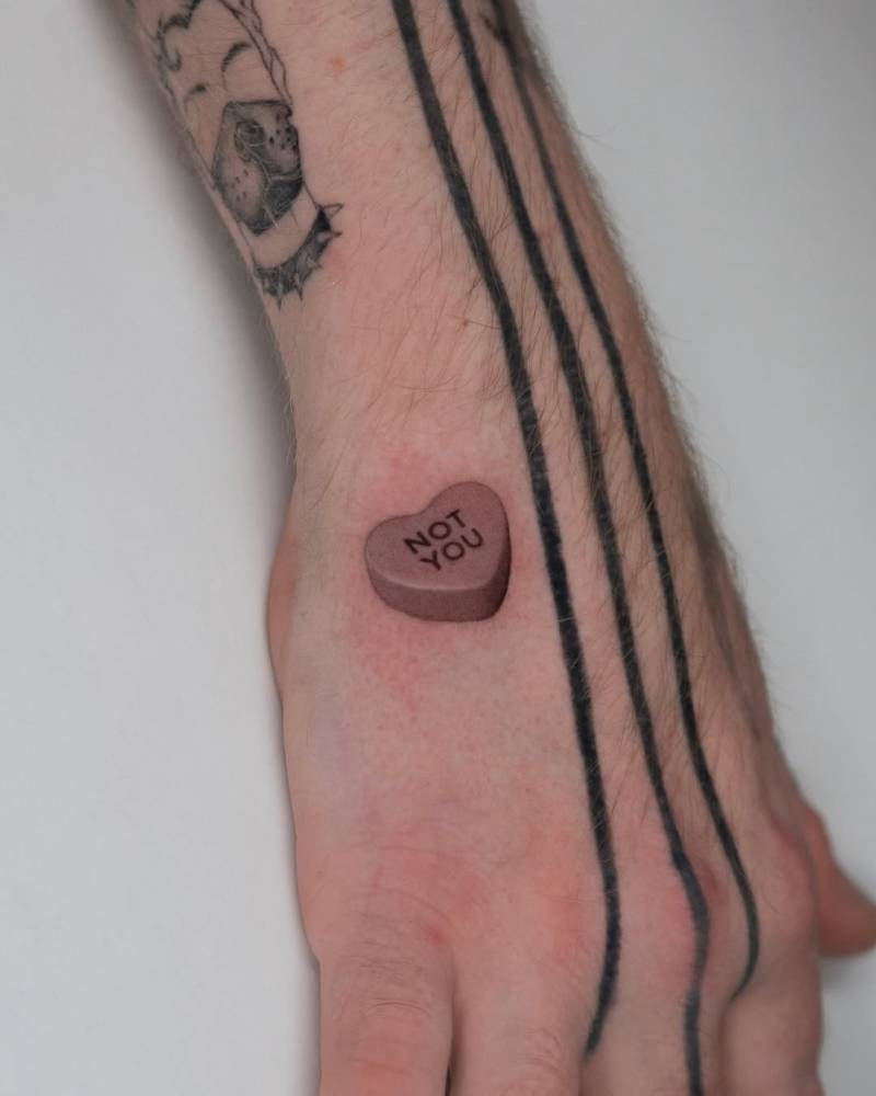 "Now you" sweetheart tattoo located on the hand.