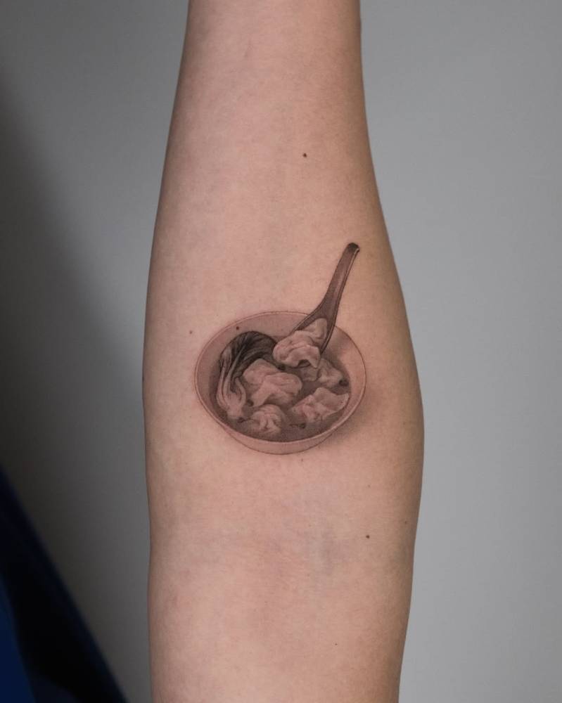 Soup tattoo located on the inner forearm, micro-realistic style.