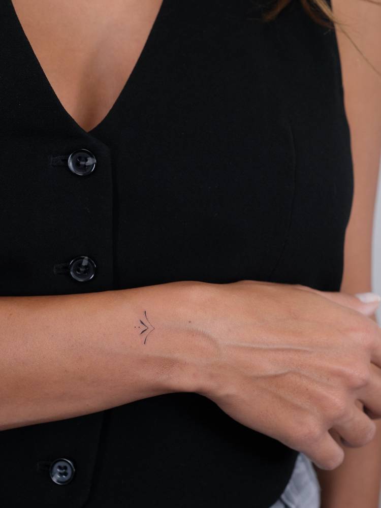 Minimalistic ornamental tattoo located on the wrist.