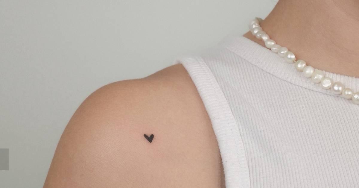 Minimalistic micro heart tattoo located on the