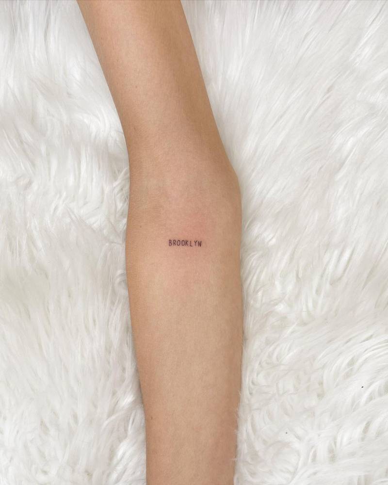 "Brooklyn" lettering tattoo located on the inner forearm.