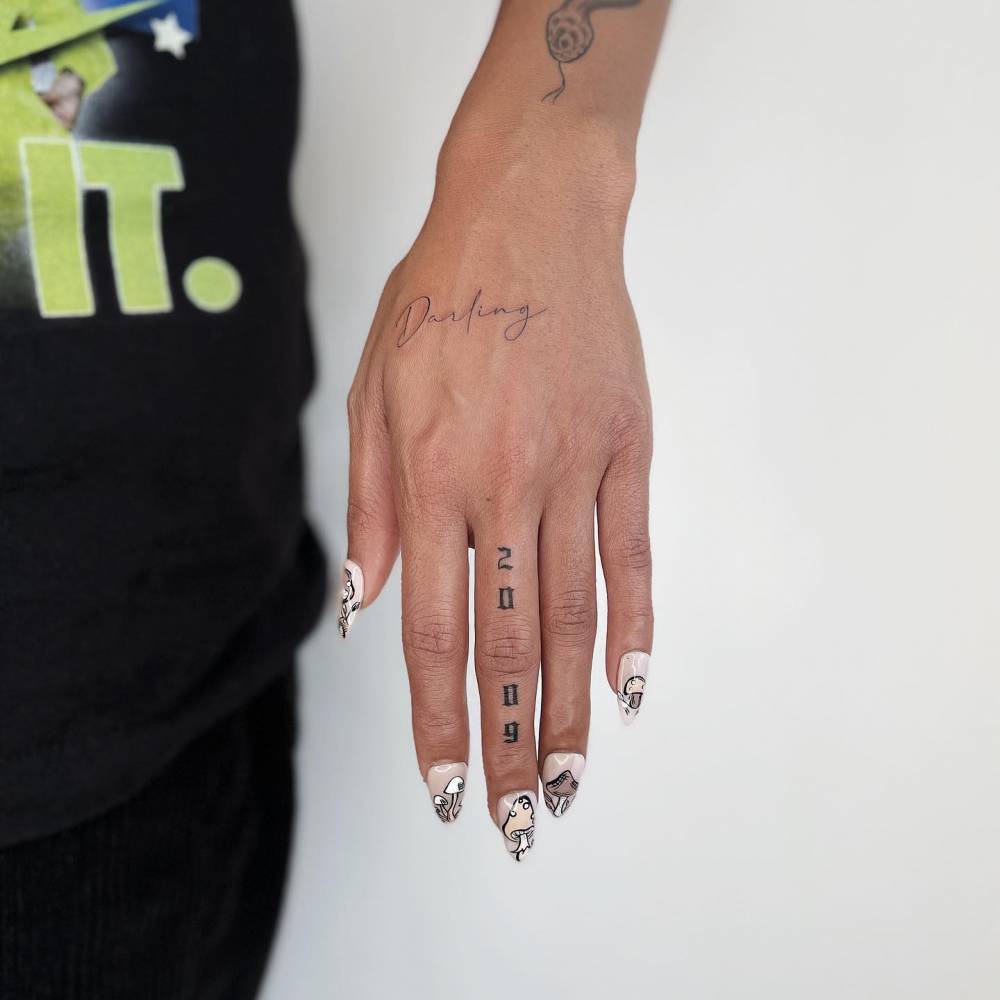 "2009" lettering tattoo done on the finger.