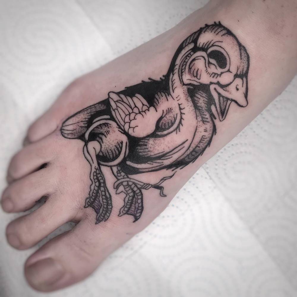 Blackwork style duck tattoo located on the foot.