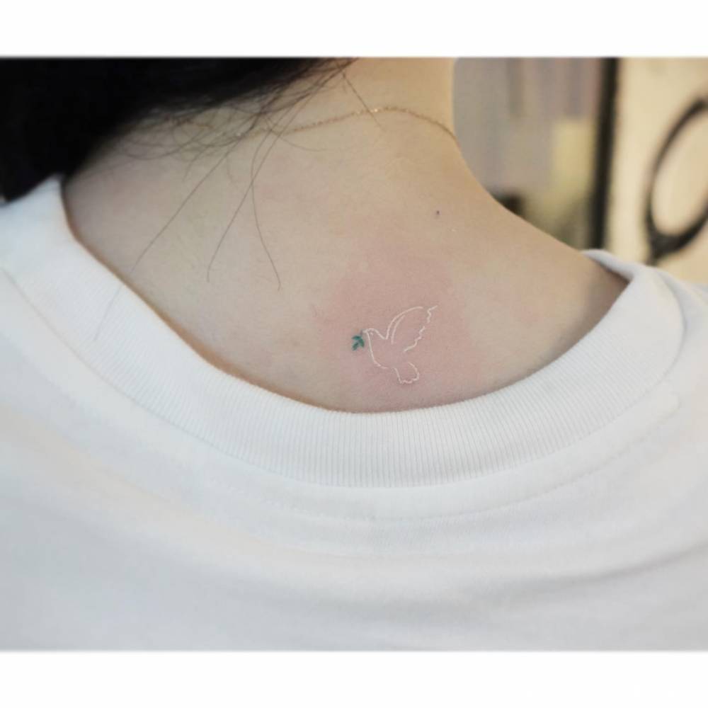 Dove tattoo in minimalistic style located on the upper back.