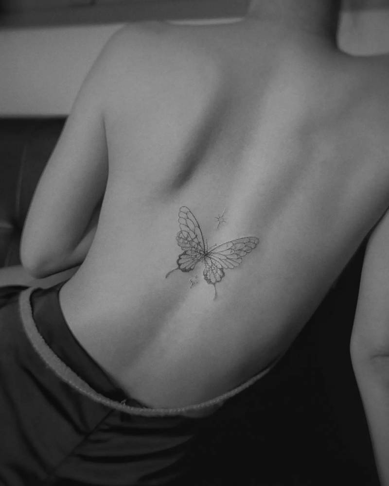 Hand poked butterfly tattoo located on the back.